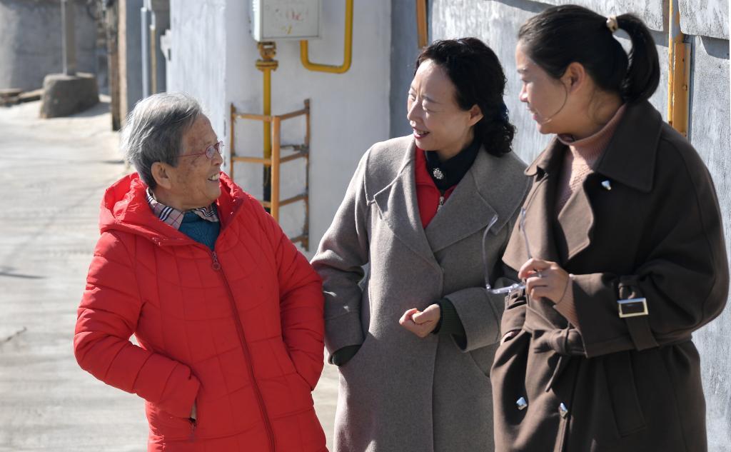 在陜西省榆林市佳縣,路生梅與志愿服務機構的工作人員聊天(2022年11月15日攝)。新華社記者 鄒競一 攝